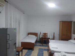 都拉斯Vila Hyseni的客房设有两张床和一台冰箱。