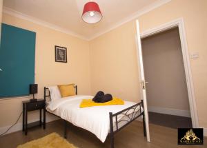 法恩伯勒Modern Luxury house in Farnborough的一间卧室配有一张黄色毯子床
