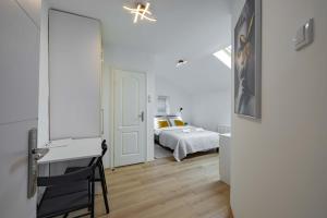 诺维萨德Old Town Rooms的白色的客房设有一张床、一张书桌和一间卧室
