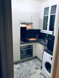 布洛涅-比扬古Appartement 60 m², porte de Saint-Cloud的一间带水槽和洗碗机的小厨房