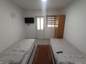 ProlomApartmani Lovcen的小型客房的两张床,设有门