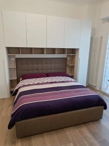 米兰Lucania25的一间卧室配有一张带白色橱柜的大床