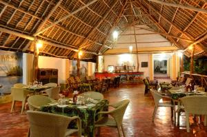乌罗阿考雷沙滩小屋的一间在房间内配有桌椅的餐厅