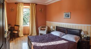 察夫塔特Boutique Hotel Villa Pattiera的一间卧室配有一张带橙色墙壁和窗户的床
