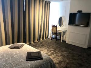 罗奇福德AC Lounge 125的酒店客房配有一张床、一张书桌和一台电视。