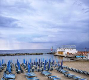 圣雷莫Casa Matuzia的海滩上的蓝色椅子和小船