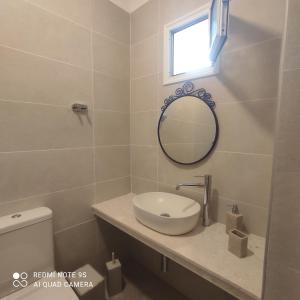 阿莫利亚尼岛纳法斯卡公寓的一间带水槽和镜子的浴室