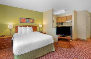 纽波特纽斯Extended Stay America Suites - Newport News - Yorktown的配有一张床和一台平面电视的酒店客房