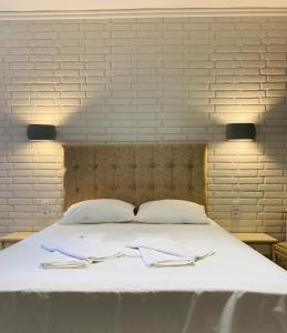 Apidias Lakos格拉湾公寓式酒店的一张白色的大床,上面有两张餐巾纸