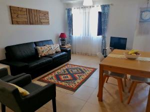 米尔芳提斯城Apartamento Praiamar的客厅配有黑色沙发和桌子