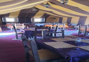 梅尔祖卡Luxury Desert Romantic Camp的帐篷内带桌椅的用餐室