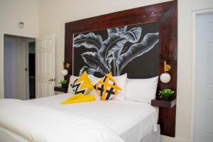 BoscobelKing Bed Studio/Gated/Fast Wi-Fi/Near Ocho Rios的卧室配有一张白色的床和大型床头板