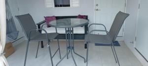 BoscobelKing Bed Studio/Gated/Fast Wi-Fi/Near Ocho Rios的玻璃桌和椅子