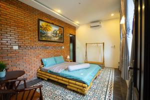 顺化Tâm Family Homestay-Huế的卧室配有床,靠砖墙