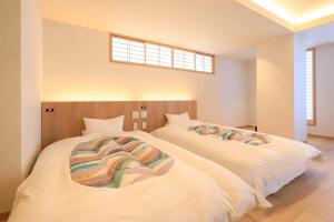 热海Yuyado Mikannoki的卧室设有2张白色的床和窗户。