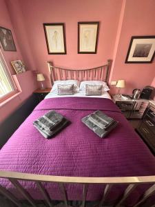 勒德洛Green Dragon LUDLOW的一间卧室配有一张紫色床和两条毛巾