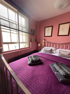 勒德洛Green Dragon LUDLOW的粉红色的卧室配有一张带紫色床单的大床