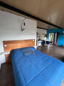 塞拉纳镇Casa CALMA en Villa Serrana的一间卧室,卧室内配有一张蓝色大床
