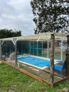 塞拉纳镇Casa CALMA en Villa Serrana的玻璃房子里的游泳池
