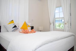 BoscobelModern & Spacious 2-BDRM/ Gated/Near Ocho Rios的卧室配有一张大白色床和窗户