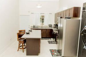 BoscobelModern & Spacious 2-BDRM/ Gated/Near Ocho Rios的厨房配有冰箱和桌椅