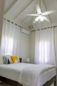 BoscobelModern & Spacious 2-BDRM/ Gated/Near Ocho Rios的白色卧室配有吊扇和1张床