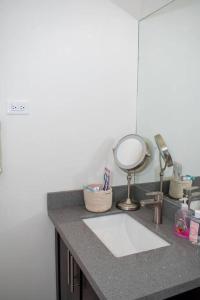 BoscobelModern & Spacious 2-BDRM/ Gated/Near Ocho Rios的浴室的柜台设有水槽和镜子