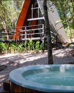 圣若热岛Sítio Aroeira Cabanas的树和房子前的热水浴池