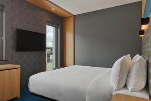 阿伯丁Aloft Aberdeen TECA的卧室配有白色的床和电视。