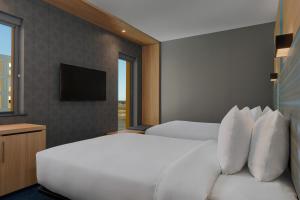 阿伯丁Aloft Aberdeen TECA的酒店客房设有两张床和电视。