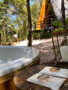 圣若热岛Sítio Aroeira Cabanas的浴缸坐在树旁的桌子上