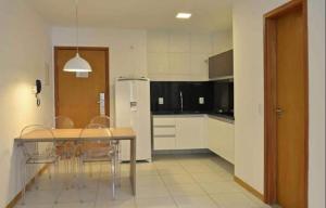 拉巴拉德纳圣米格尔Residencial ILOA的厨房配有桌椅和冰箱。