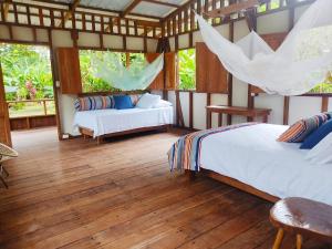 巴亚索拉诺Reserva Pakore Wera的一间卧室设有两张床,铺有木地板