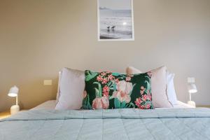 坎贝尔港斯里弗默别墅酒店的床上有花枕头