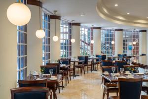 迈阿密迈阿密戴德兰万豪酒店的餐厅设有桌椅和大窗户。