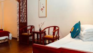 北京北京合德缘四合院酒店的配有床和两把椅子及一张桌子的房间