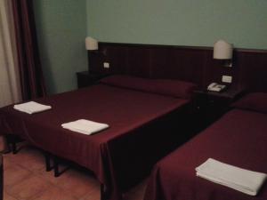 RoccamandolfiCasale Maginulfo的酒店客房,配有两张带红色床单的床