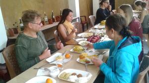 达瓦拉维Italiano Safari House的一群坐在餐桌上吃食物的人