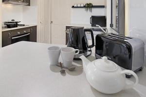布里斯班Terbium Sanctuary的厨房柜台配有茶壶和茶杯