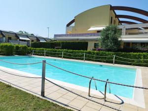锡罗洛Appartamento L'Azalea - a due passi da Numana con grande terrazzo e piscina condominiale stagionale的大楼前的大型游泳池