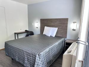 亚特兰大Masters Inn Atlanta - Doraville at I-85 & 285的配有一张床和一把椅子的酒店客房