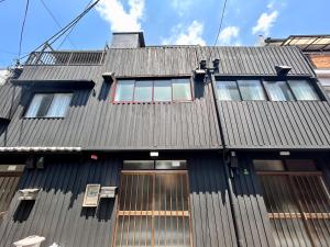 大阪Modern and Traditional Fusion Villa in Umeda 3-Min Walk to Subway Ideal for Families and Groups的一座带窗户的黑色屋顶建筑