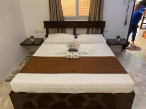 波尔多·格尼拉帕帕弗雷德斯海滩度假酒店的一间卧室配有一张大床,上面有标志