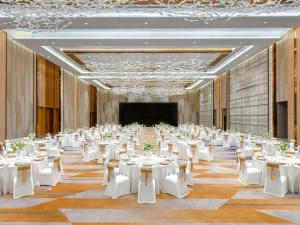 广州广州南沙越秀喜来登酒店的一个带白色桌椅的大型宴会厅