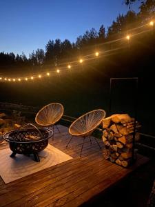 ÄhijärveKarula Stay Romantic and Luxurious Glämping in Karula National Park的一个带两把椅子和烧烤架的甲板