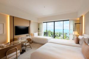 恩纳Halekulani Okinawa的酒店客房设有两张床和电视。