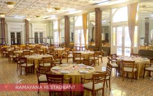 梭罗Ramada Suites By Wyndham Solo的宴会厅配有桌椅和窗户