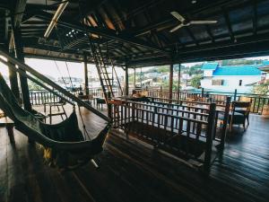 纳闽巴霍Cool Breeze Authentic Hotel Labuan Bajo Komodo的配有桌椅的客房内的吊床