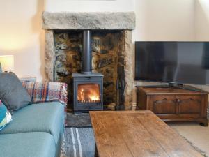 Great LongstoneCorner Cottage的客厅设有壁炉和沙发。