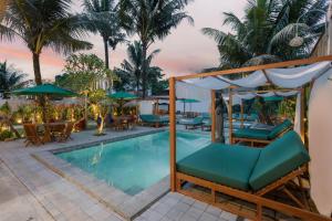 乌布Horison Ume Suites & Villas的一个带躺椅和遮阳伞的度假游泳池